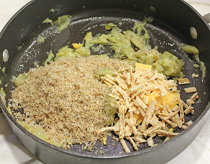 Cheese and breadcrumbs being added to saute´d  eggplant