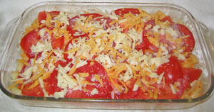 Macaroni & Cheese, layered with sliced tomatoes and topped with cheese. Ready to be baked